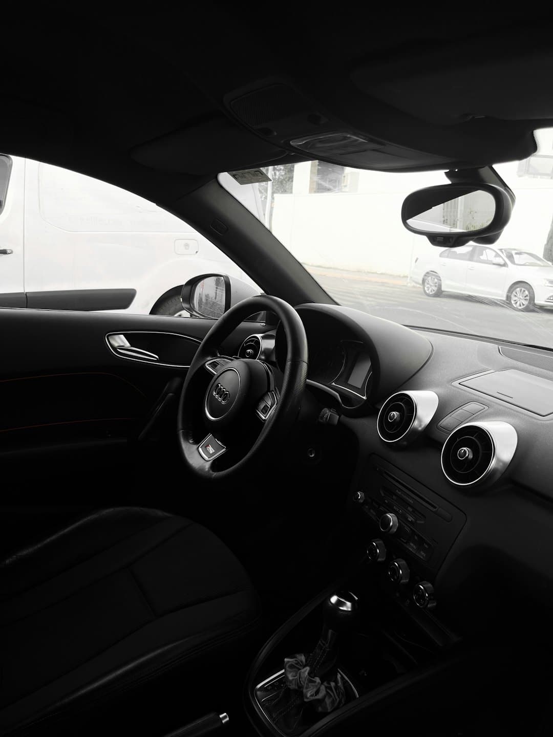 The steering wheel and dashboard of a modern Audi car.